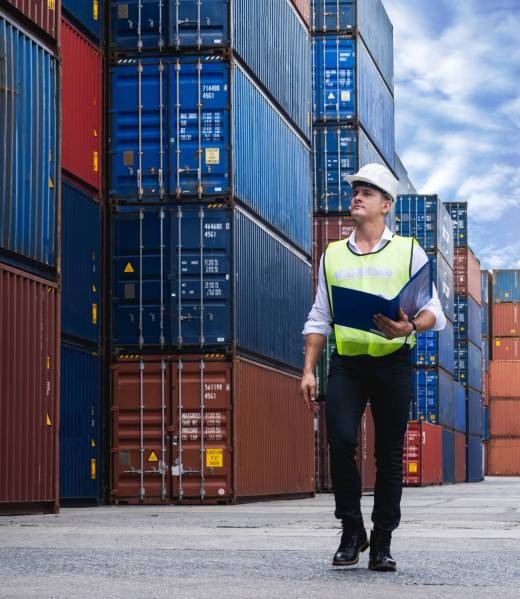 Foreman holding document, walking and checking the containers box from cargo ship for export and import